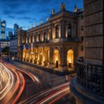 Historic European stock exchange building at night with light trails symbolizing financial markets in stocks vs real estate in Europe
